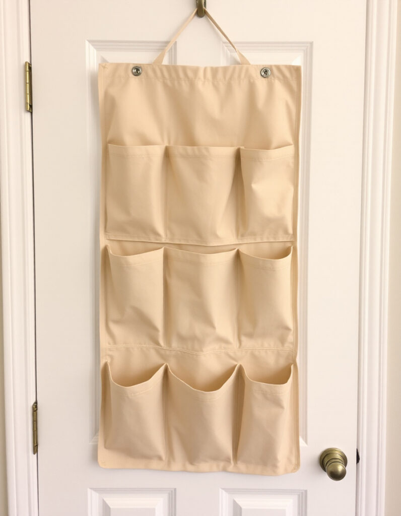 A neutral fabric organizer hanging over a white door.