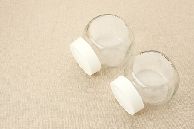 Empty glass spice jar with plastic lid.